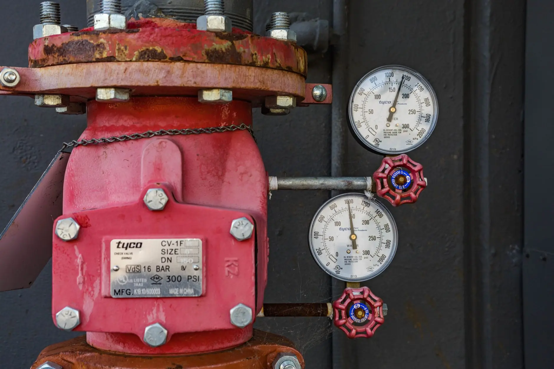 Red industrial valve with pressure gauges